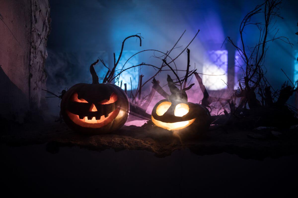 5. Muzica si ambianta pentru o petrecere de Halloween reusita doi dovleci sculptati si lumini colorate la ferestrele unei case